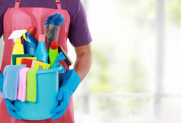commercial cleaner holding a bucket of cleaning products